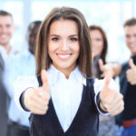 attractive businesswoman with team in office showing thumbs up