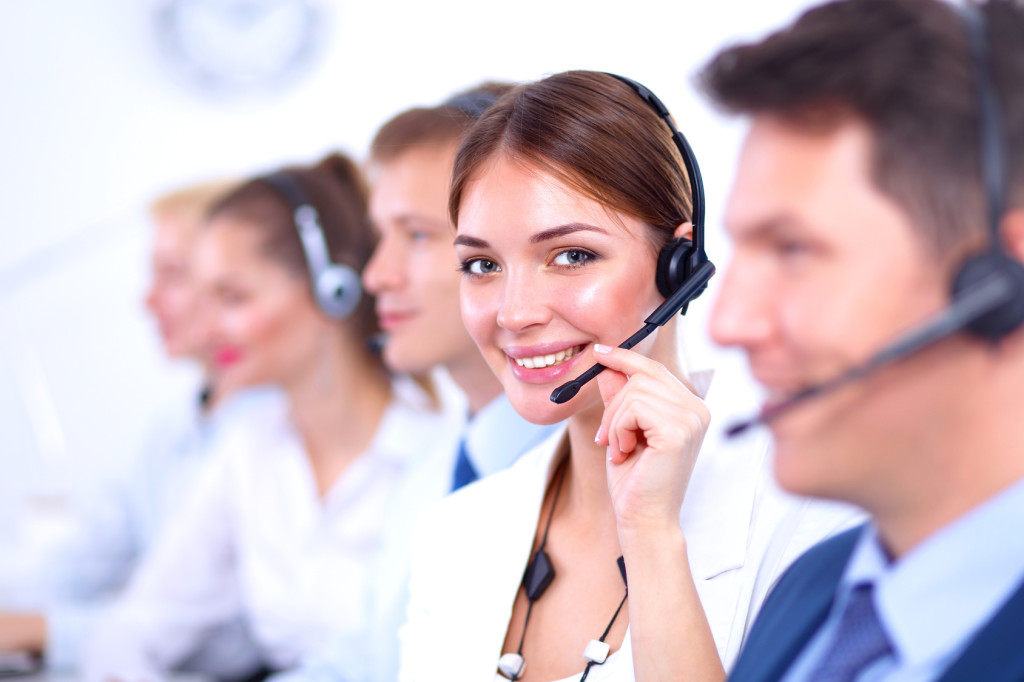 Attractive Smiling positive young businesspeople and colleagues in a call center office